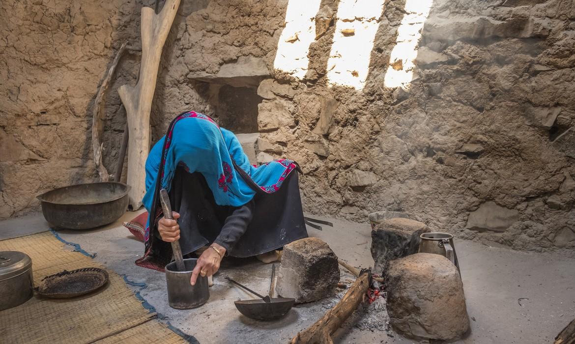 Omani woman in traditional outfit preparing coffee, Al Hamra